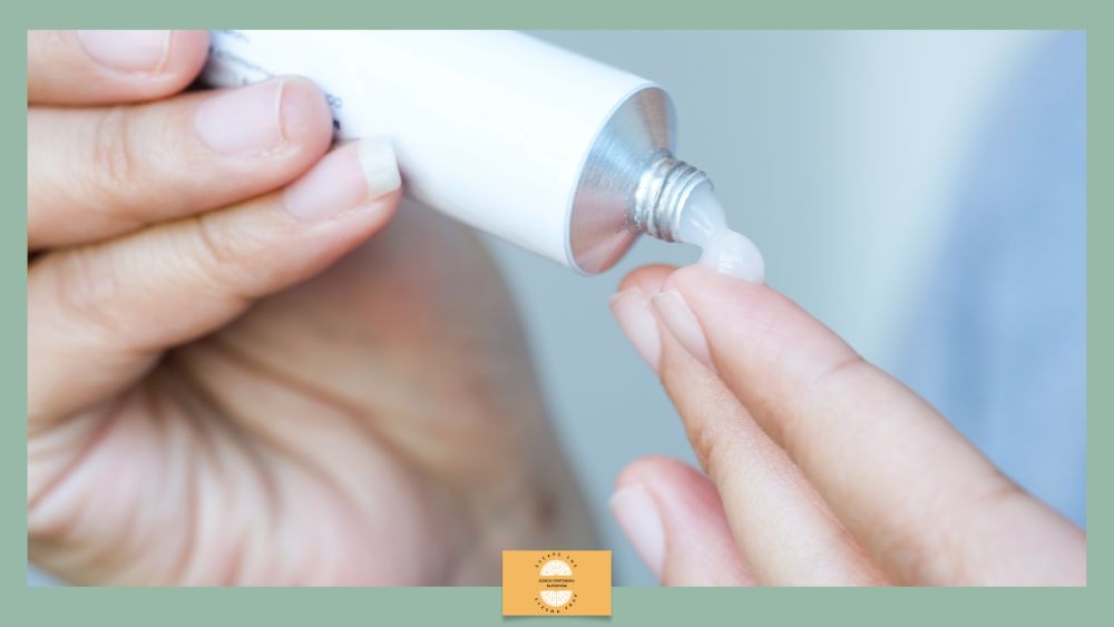 Close-up of a person squeezing toothpaste onto their fingertip from a tube for dental care.